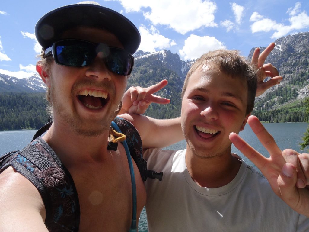 Hikers having fun with a lake and mountains behind them.