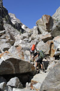 Climbers scrambling through a field of large boulders, Garnet Canyon, Grand Teton National Park.