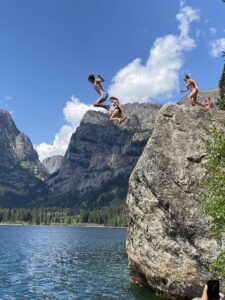 Teenagers Jumping off a rock into a mountain lake.