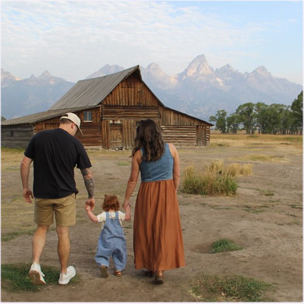 GrandTetonFamilyTourToddlerMormonBarn Guides of Jackson Hole Parents walk their toddler towards the Moulton Barns in Grand Teton National Park