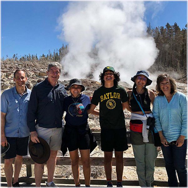 YellowstoneFamilyTourHappyFamily Guides of Jackson Hole A family before a hot spring in Yellowstone